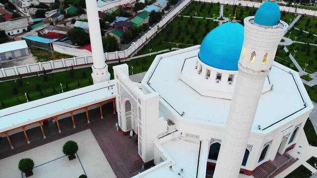 A drone flies over a beautiful mosque in the early hours of the morning. On the background of dawn in a cloudy sky.