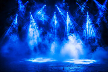 Fototapeta premium A dramatic stage scene with blue lighting and fog, creating an atmospheric setting for a performance or event.