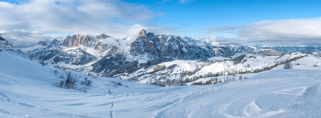 Panoramic view in the alta badia ski resort in the Dolomites in winter with ski slopes and the Sassongher mountain in the background