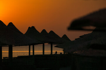 Close-up of beach umbrellas - beautiful setting sun in the background. Beach on the Red Sea, Egypt © ukasz