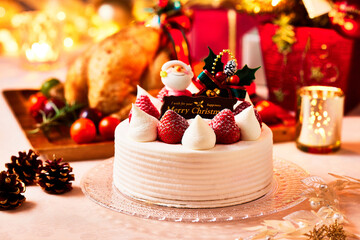 クリスマスケーキ、ガラス製のお皿に生クリームとイチゴのケーキ黄金に輝く贅沢なイメージ