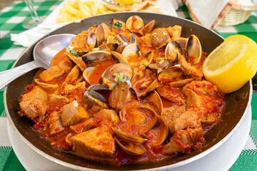 Traditional Portuguese dish: tender pork, clams, simmered in a savory garlic and white wine sauce, served Alentejo-style. A flavorful blend of land and sea on one plate.