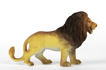 Brown and yellow plastic toy lion isolated on white background. Concept of jungle animals and mammals