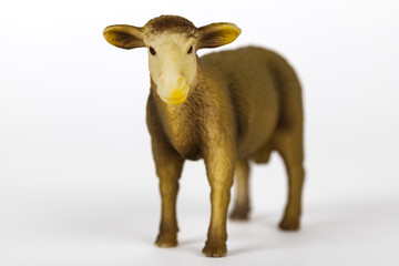 Light brown plastic toy sheep isolated on white background. Concept of farm animals and mammals