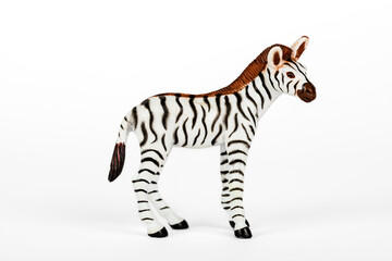 Black and white plastic toy zebra isolated on white background. Concept of jungle animals and mammals