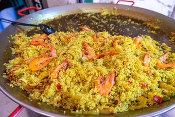 Delicious seafood paella, vibrant with fresh shrimp, clams, and colorful vegetables, served in a traditional pan. A mouthwatering dish that captures the essence of Mediterranean cuisine.