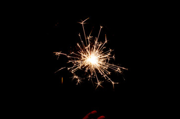 Sparklers sparkle brightly against a black background, creating the effect of magic and celebration, filling the atmosphere with joy