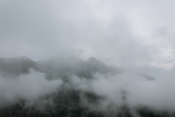 Misty mountains at dawn, shrouded in a soft veil, create a magical atmosphere of tranquility and mystery of nature