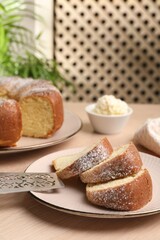 Pieces of freshly baked sponge cake, server and ice cream on wooden table, closeup