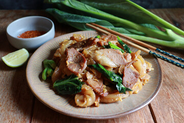 Stir fried rice noodle with soy sauce, pork meat, egg and Chinese Broccoli. Thai street food Pad See Ew.