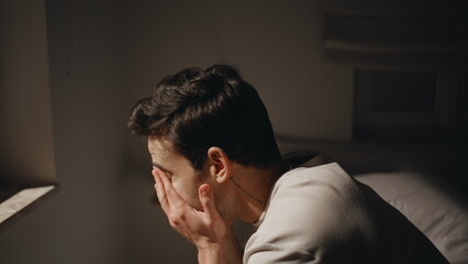 Despair grip man sitting in dark bedroom at night closeup. Guy showing stress