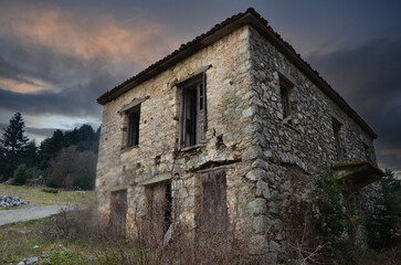 Fototapeta premium Haunted Scene House. An old vintage creepy stone house under a dramatic dark sky
