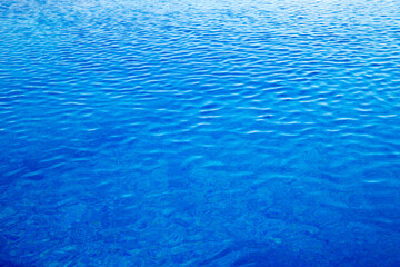 Water in swimming pool rippled water detail background.  Blue in the water in the swimming pool.