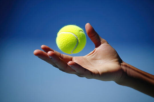A person is holding a tennis ball in their hand