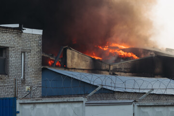 Massive large blaze fire in the city, blazing warehouse factory, storage building is burning,...
