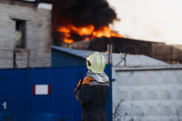 Massive large blaze fire in the city, blazing warehouse factory, storage building is burning,...