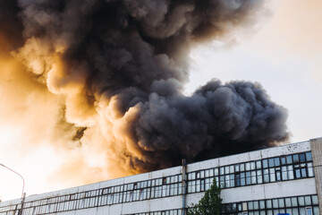 Massive large blaze fire in the city, blazing warehouse factory, storage building is burning,...