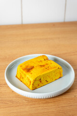 Marinated tofu cube ready for cooking, showcasing a vibrant golden-brown color with herbs and spices. Ideal for healthy meal prep and vegetarian recipes.