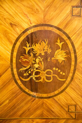 A wooden panel with a pattern of flowers in a circle of yellow and brown, eighteenth century. The products are made using ancient technologies. World tourism.