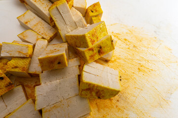 Marinated tofu strips arranged neatly on a cutting board, showcasing a delicious, healthy ingredient perfect for various culinary dishes and plant-based recipes.