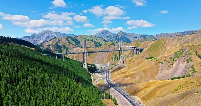 Cable stayed bridge across valley. majestic Guozigou Bridge and mountain range scenery in Xinjiang, China.