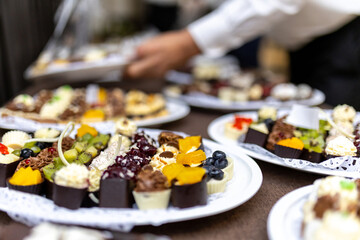 A delightful assortment of desserts served on elegant plates during a festive gathering in a luxurious setting