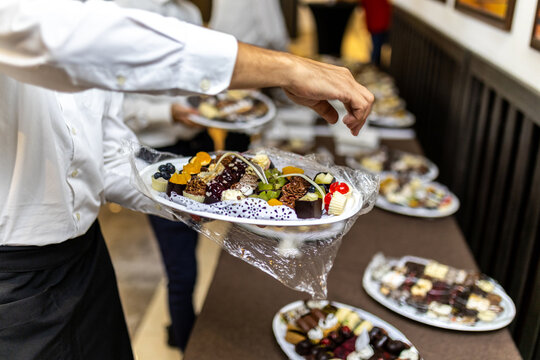Chef serving beautifully plated desserts at an elegant event