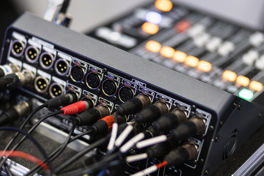 Close-up view of audio mixing console with cables connected during a live event setup process