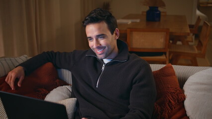 Freelancer discussing work online by laptop virtual chat at home. Smiling man