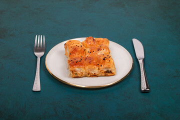 Plate of Turkish Cheese Borek with Fork and Knife – Flaky Pastry with Sesame Seeds, Ideal for Traditional Turkish Cuisine and Mediterranean Food Presentations