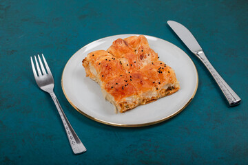 Plate of Turkish Cheese Borek with Fork and Knife – Flaky Pastry with Sesame Seeds, Ideal for Traditional Turkish Cuisine and Mediterranean Food Presentations