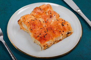 Plate of Turkish Cheese Borek with Fork and Knife – Flaky Pastry with Sesame Seeds, Ideal for Traditional Turkish Cuisine and Mediterranean Food Presentations