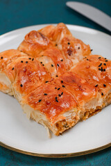Plate of Turkish Cheese Borek with Fork and Knife – Flaky Pastry with Sesame Seeds, Ideal for Traditional Turkish Cuisine and Mediterranean Food Presentations