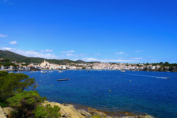 view from the Platja des Sortell, to the beautiful white houses of Cadaqu&eacute;s, Port Alguer and the turquoise water of the Mediterranean Sea, mountains of the Pyrenees behind, Girona, Catalonia, Spain