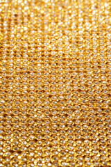 Gold lace with rhinestones shimmers, creating an impression of luxurious texture. Perfect for background or concept of elegance and wealth. Suitable for topics about fashion, jewelry, designer details