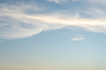 Aerial view of fluffy white clouds drifting across the blue sky on a sunny day