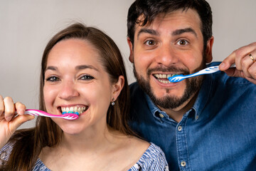 Pareja sonriente lavándose los dientes juntos. Fotografía conceptual de salud bucal