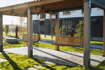 A vibrant and lively outdoor playground featuring beautiful wooden swings set in a contemporary park environment, perfect for enjoyment and adventure