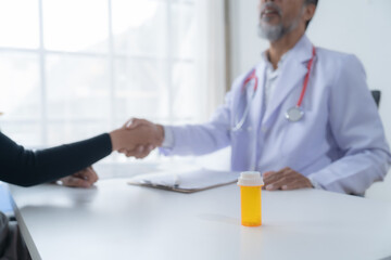 Doctor warmly greets a patient at a desk with medicine, exuding trust and empathy. Their partnership focuses on wellness, supported by a warm background