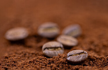 Coffee beans on ground coffee background