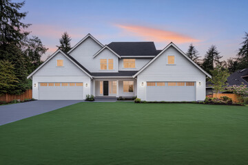 Obraz premium Modern suburban house at twilight with beautifully manicured lawn and surrounding trees