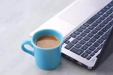 オフィスでデスクワークの合間に、牛乳をたっぷり入れたコーヒーのカフェ・ラッテを飲む
