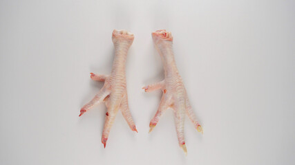 Raw Chicken feet long nail carcass section on white background 