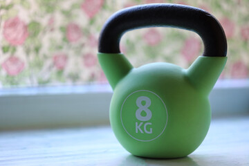 A green kettle sits on a kitchen counter, ready for use.