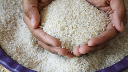 Hands holding  rice grains for zakat, Islamic zakat concept. Muslims to help the poor and needy....