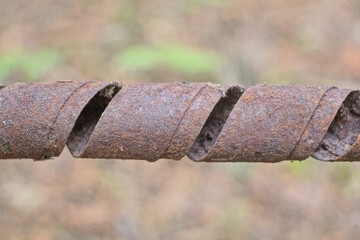brown rusty iron wire twisted into a spiral from an old spring on a gray background