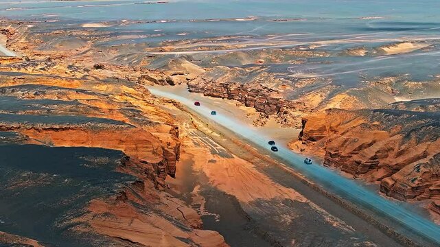 Car passing through a Yardan landform desert road. The spectacular Dahaidao Yardan landform natural landscape in Xinjiang, China. A paradise for self driving tours.