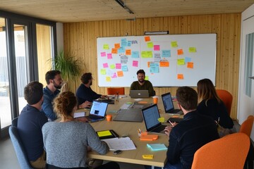 A modern office with employees engaged in a creative brainstorming session - laptops and tablets on the table.