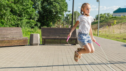 happy girl jumping with skipping rope outdoor