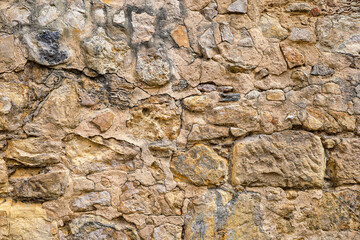 Background image formed by a degraded wall with exposed stones.